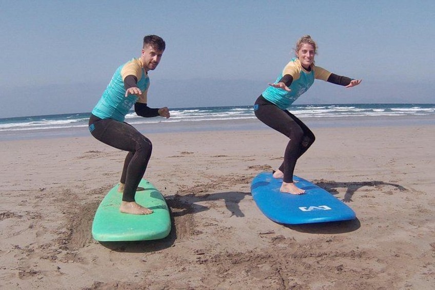 Deux personnes sur des planches de surf, sur la plage. 3