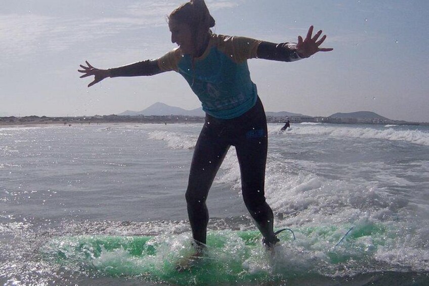 Una persona surfeando una ola en el océano, con montañas al fondo. 4
