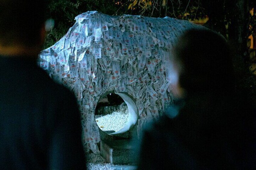 A sculpture covered in currency notes, with a circular opening at the base. 5