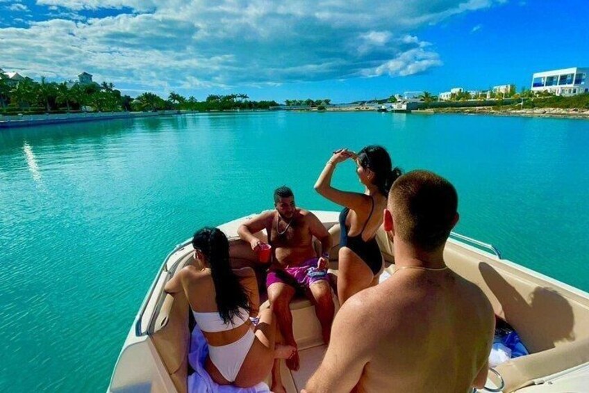 A group of people on a boat in clear turquoise water. 1