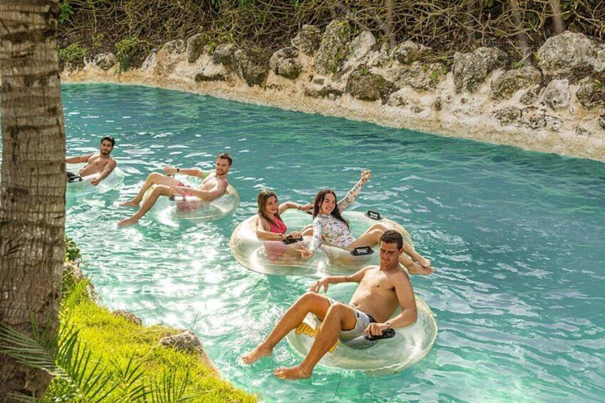 People floating on water in a natural pool surrounded by rocks and greenery. 2