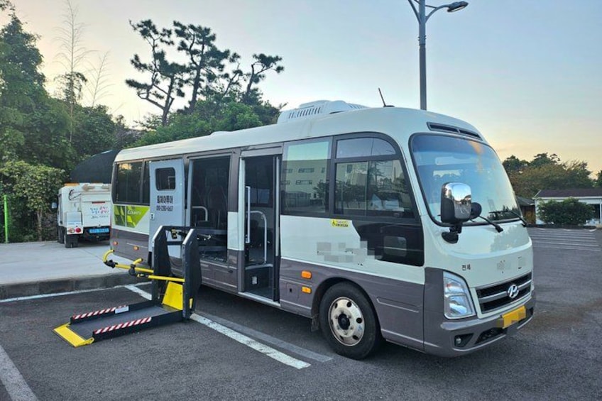 Un autobús blanco y gris estacionado en un estacionamiento con rampa para accesibilidad. 5