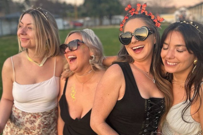 Un grupo de personas al aire libre, algunas con vestidos y una con diadema. 1