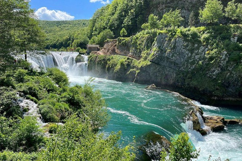 A waterfall, river, and lush greenery. 3