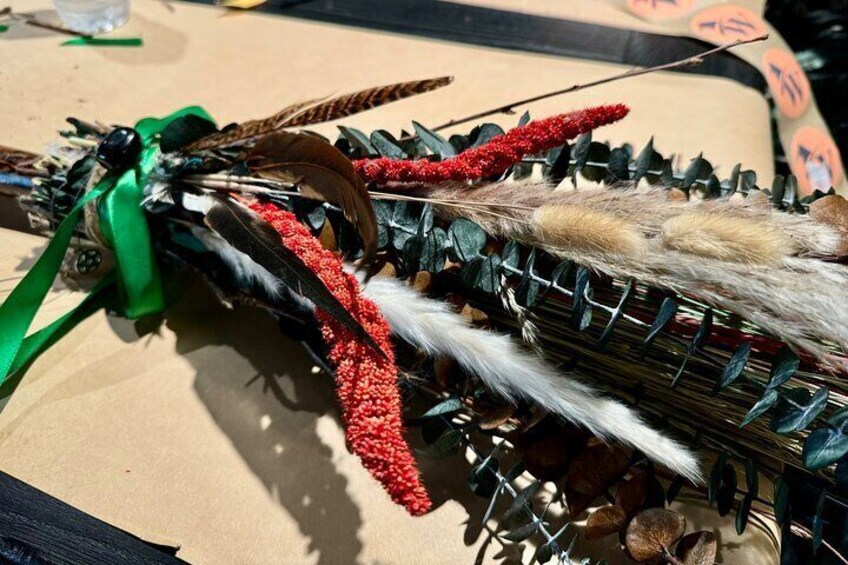 Un adorno con plumas, cuentas y un lazo verde. 3