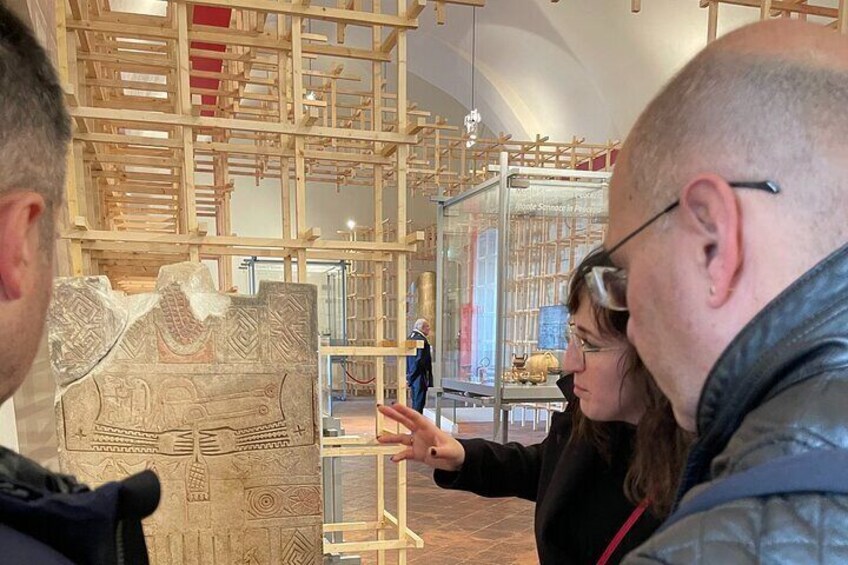 A museum interior with a large, intricately carved stone artifact on display. 4