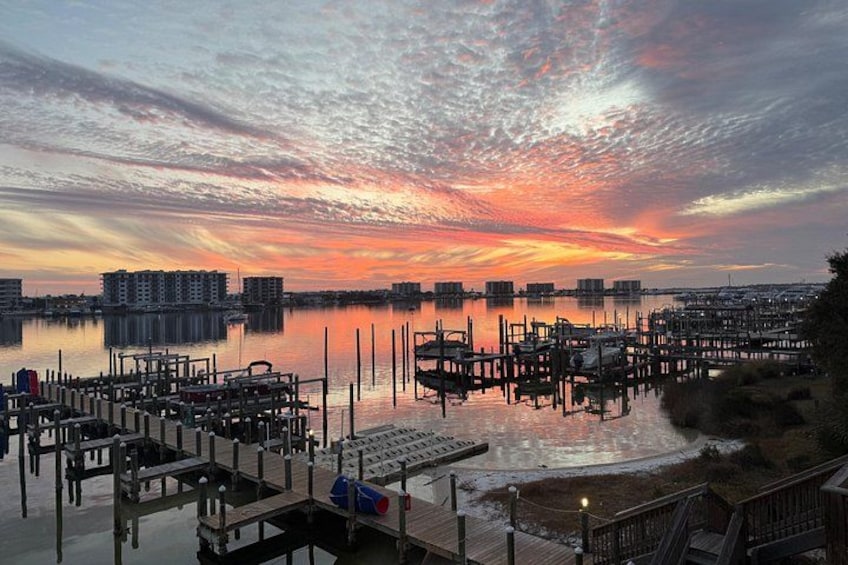 A marina with docked boats, a sunset, and buildings in the background. 5