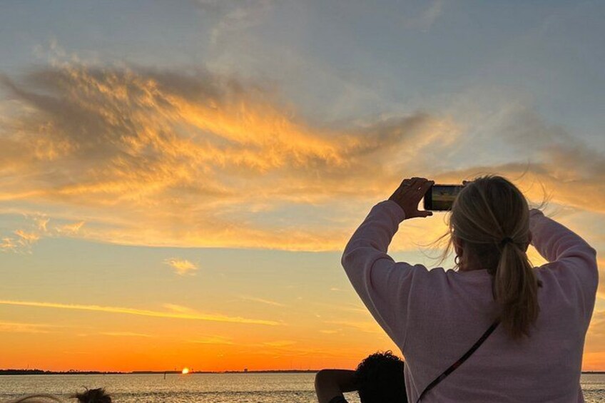 Una persona fotografiando un atardecer sobre el océano. 2