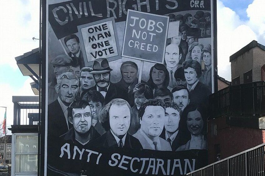 A large outdoor political poster with text and images of people. 1