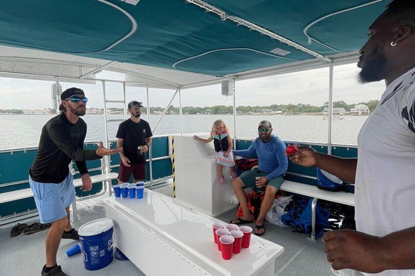 People on a boat with a table holding cups and a bucket. 2