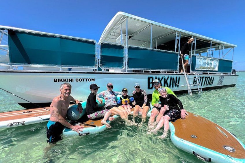 Un grupo de personas en un bote bajo un cielo azul despejado y agua tranquila. 5