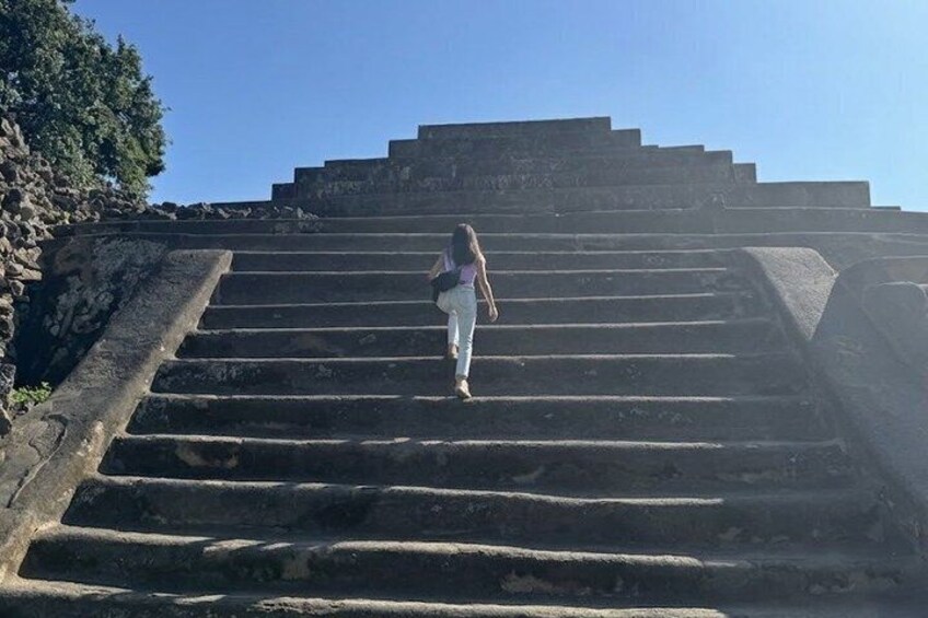 A person ascending a set of stone steps towards a structure. 4