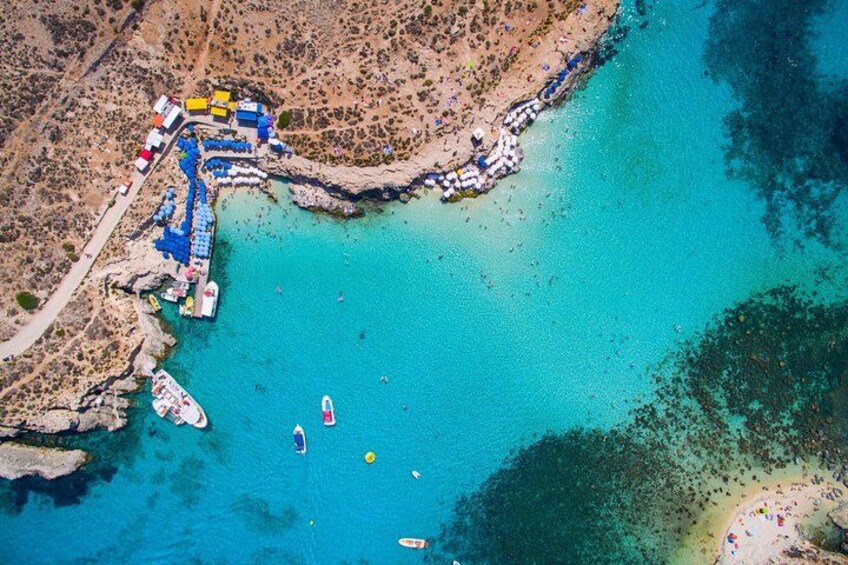 An aerial view of a coastal area with a pier, boats, and a beach. 4