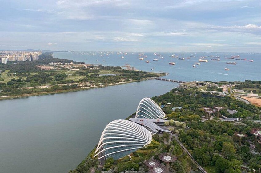 A coastal cityscape with modern architecture, a river, and a marina with boats. 4