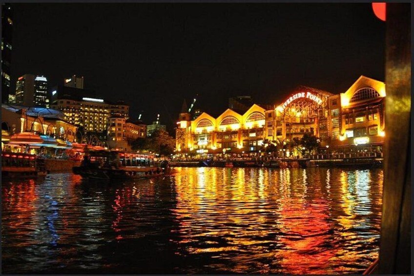 A waterfront with illuminated buildings reflecting on the water. 5