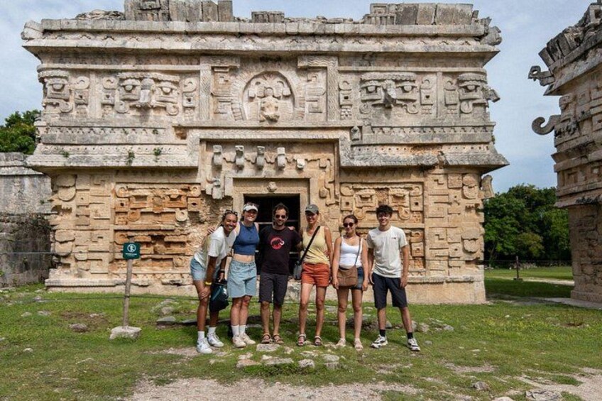 Un grupo de personas frente a una antigua estructura de piedra con intrincados grabados. 2