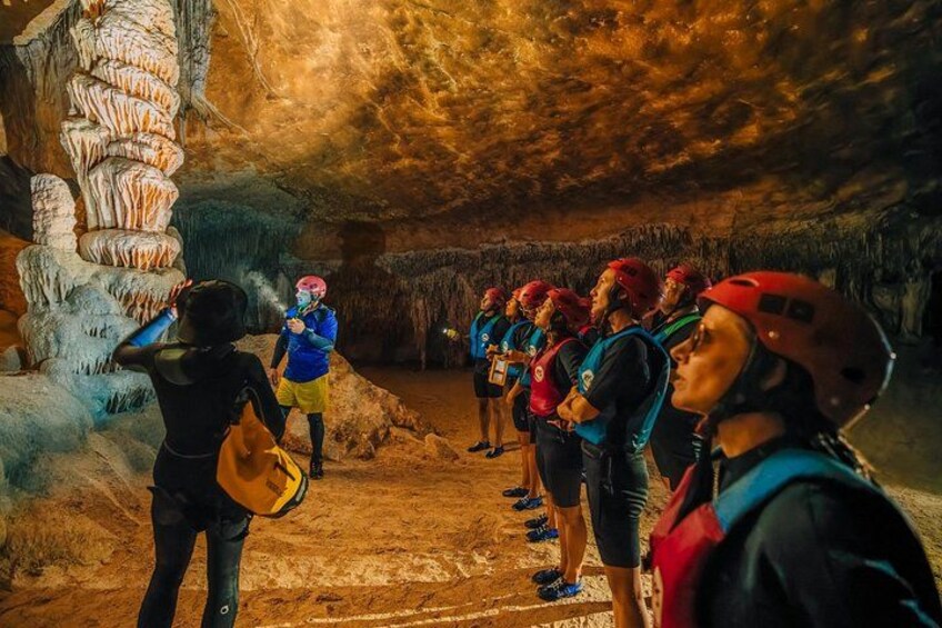 A group of people in a cave with stalactites. 5