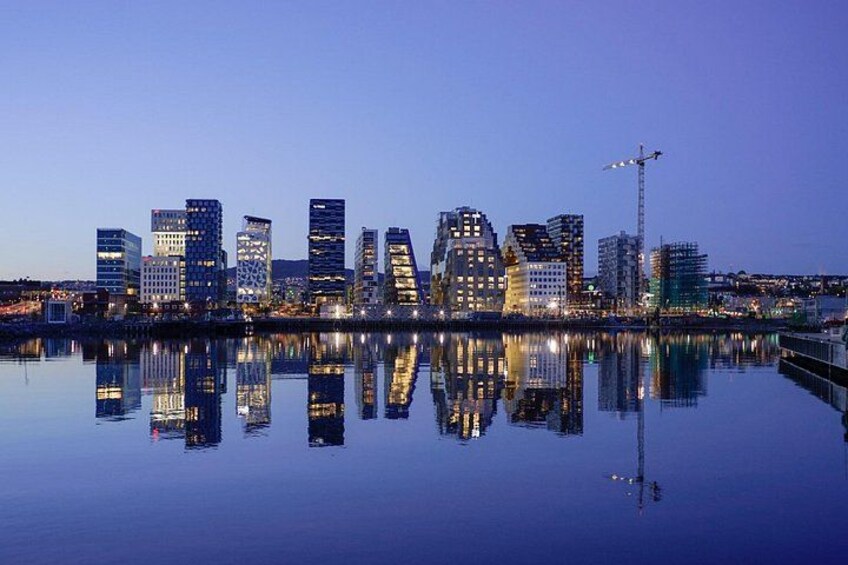 Een stadszicht in de schemering, met moderne gebouwen die in het kalme water weerspiegelen. 3