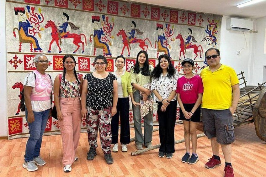 Un grupo de personas de pie en una habitación con un mural colorido en la pared. 3