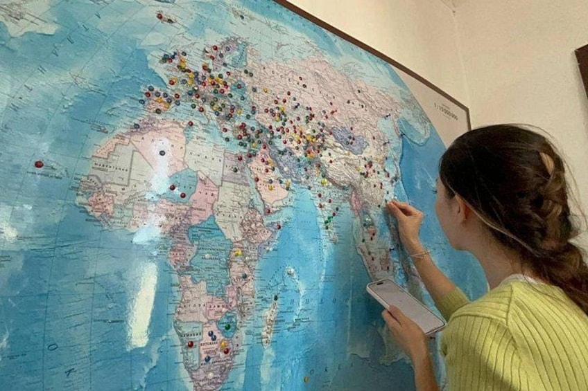 Una persona señalando un mapa mundial con chinchetas de colores. 2