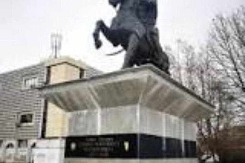 A statue of a person on a pedestal with a building in the background. 2