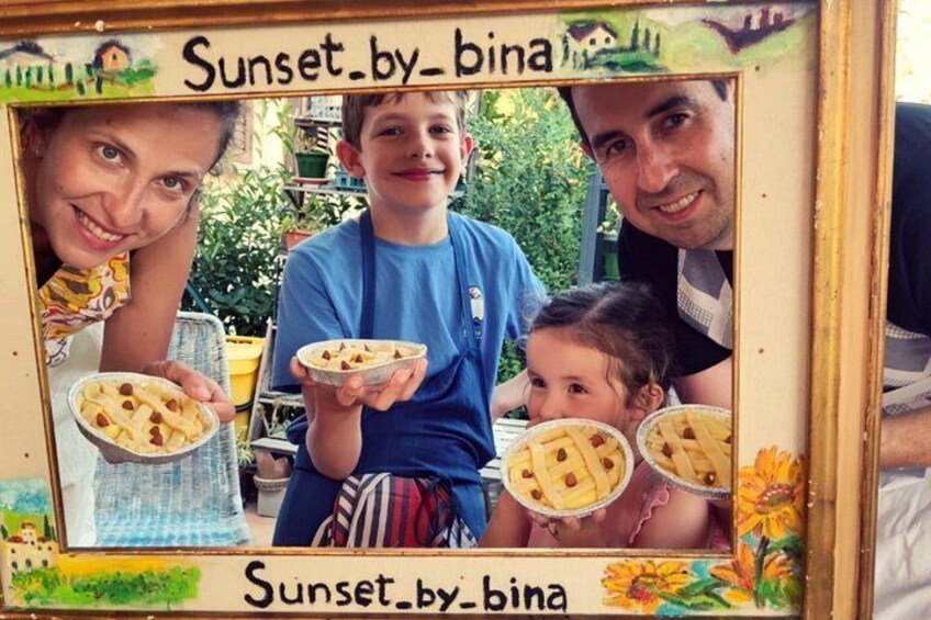 Ein gerahmtes Foto, das ein Kind zeigt, das einen Kuchen hält, und der Text 'Sunset.by-bina' steht auf dem Rahmen. 2