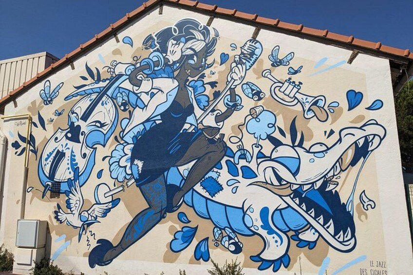 A mural with a woman playing a trumpet, surrounded by musical notes and a large blue creature. 3