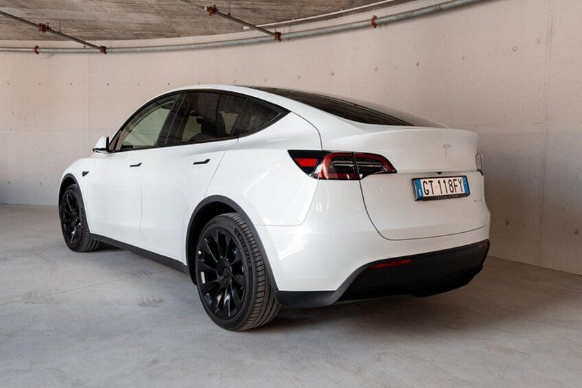 A white car parked in an indoor garage. 5