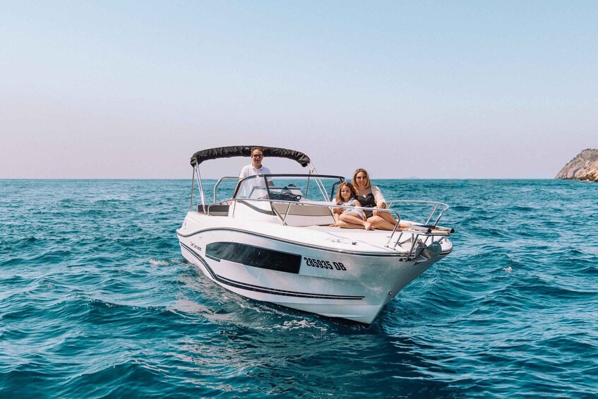 A white motorboat with the number 285935 on its side, moving through turquoise waters. 5