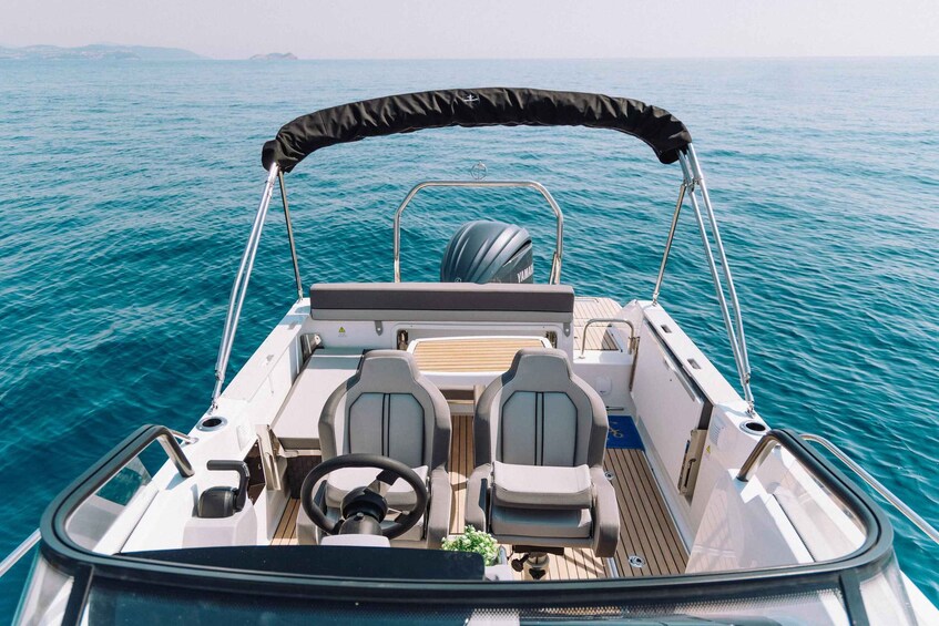 A boat's interior with two seats, a steering wheel, and a Yamaha outboard motor. 4