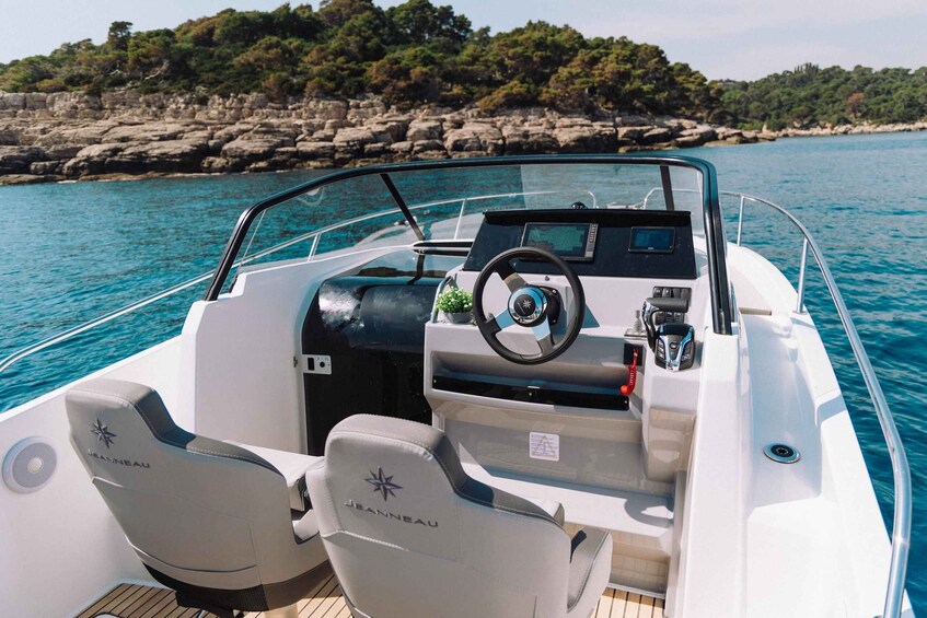 A boat's interior with two seats, a steering wheel, and a control panel. 2