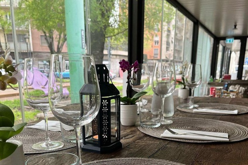Une table dressée pour le dîner, avec des verres à vin, une lanterne et un vase rempli de fleurs. 4