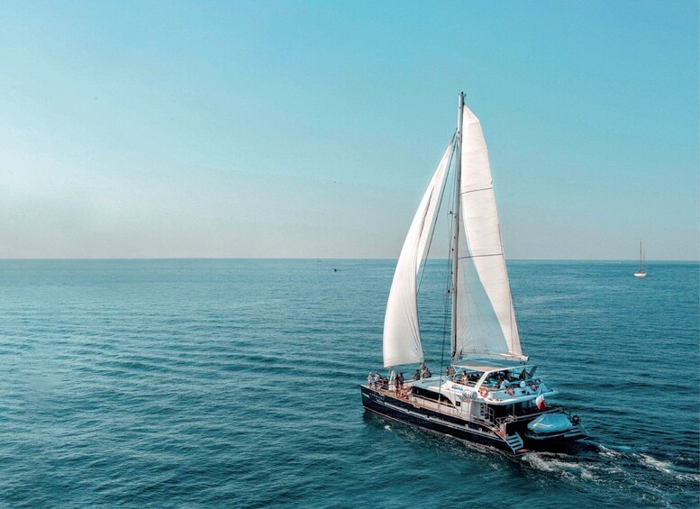 A sailboat with white sails on a calm sea. 4