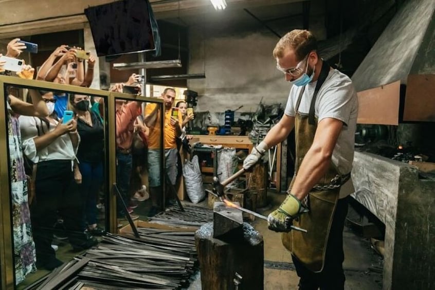 A blacksmith at work, surrounded by onlookers. 5