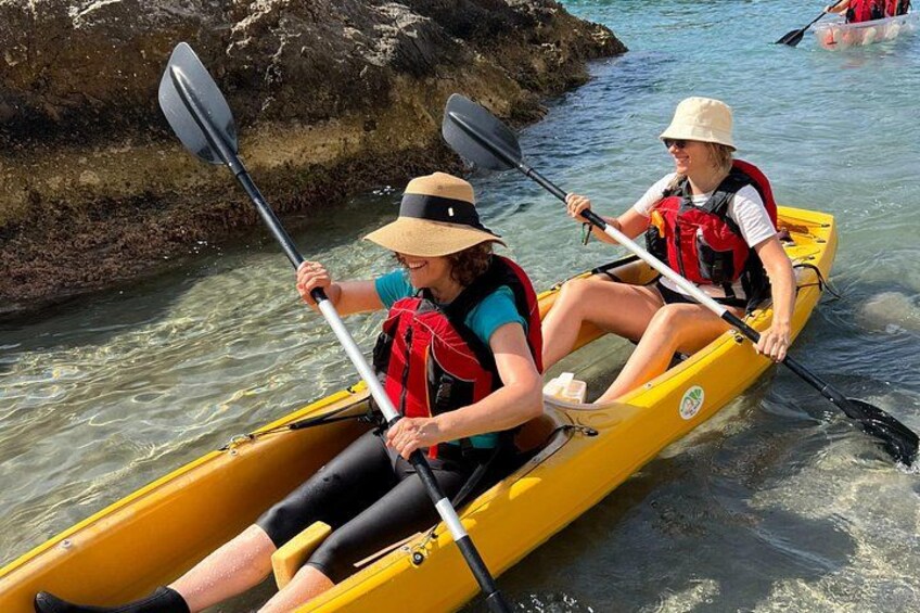 Deux personnes font du kayak dans un canoë jaune sur une rivière aux eaux claires. 2