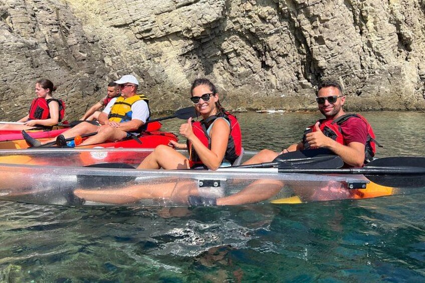 Des personnes pratiquent le kayak par une journée ensoleillée, avec des falaises rocheuses en arrière-plan. 3