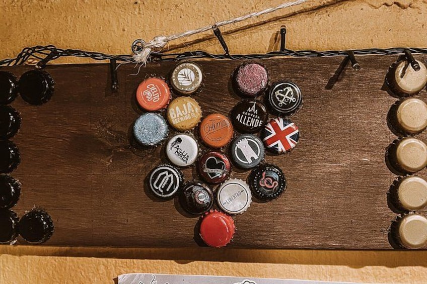 A wooden board with various bottle caps arranged on it. 3