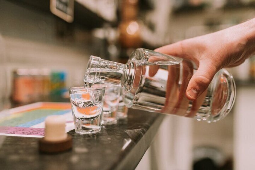 Iemand giet water uit een fles in een glas. 2