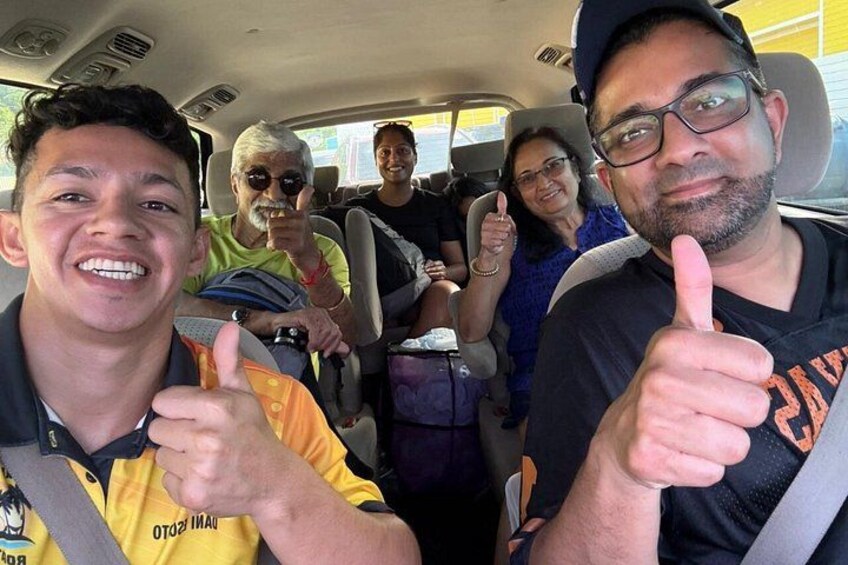 A group of people inside a vehicle, with two individuals giving thumbs up. 3
