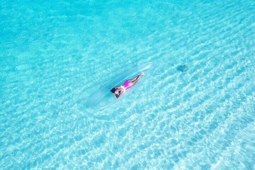 A person floating in clear blue water. 1