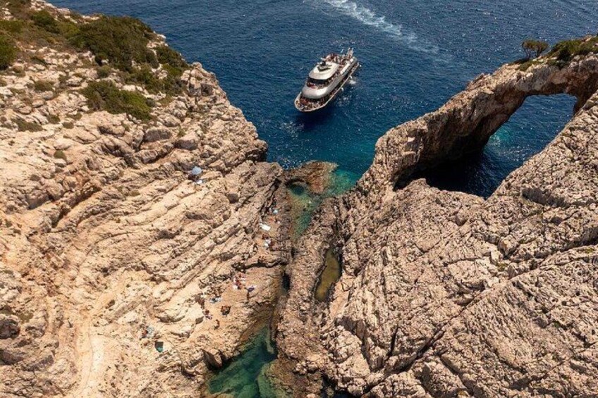 A rocky coastline with a boat navigating through a narrow passage. 3