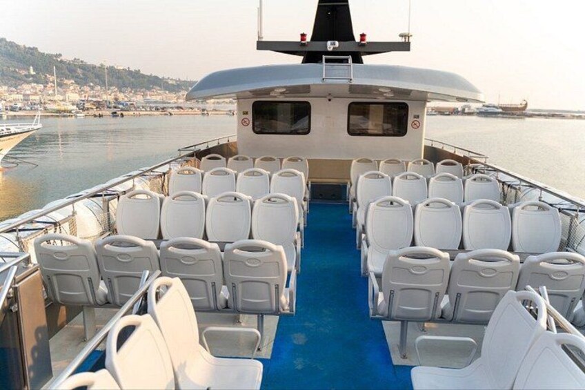 A boat with rows of white chairs and a blue floor. 4