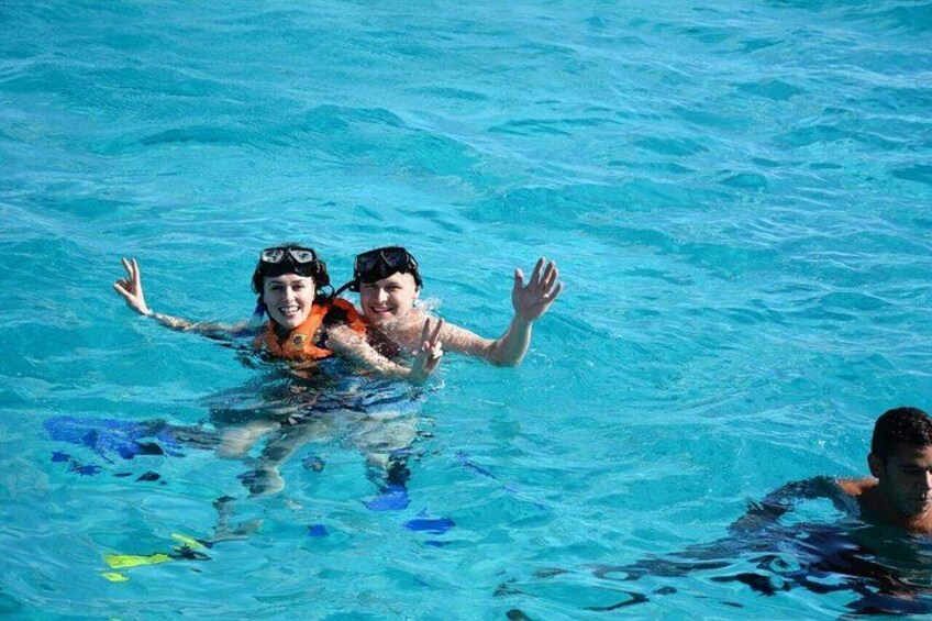Two people swimming in a pool with blue water. 5