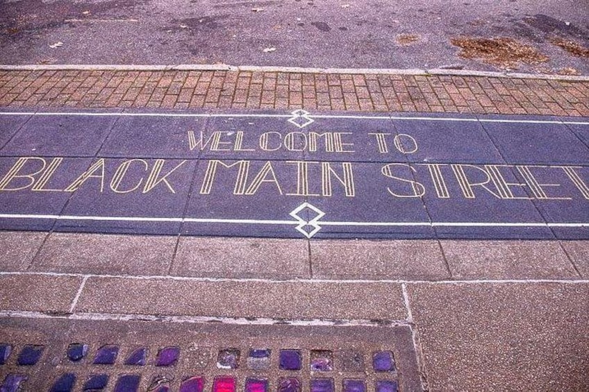 Et skilt i vejen med 'WELCOME TO BLACK MAIN STREET' malet. 3