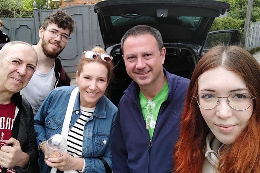 A group of people posing in front of a vehicle with an open trunk. 2