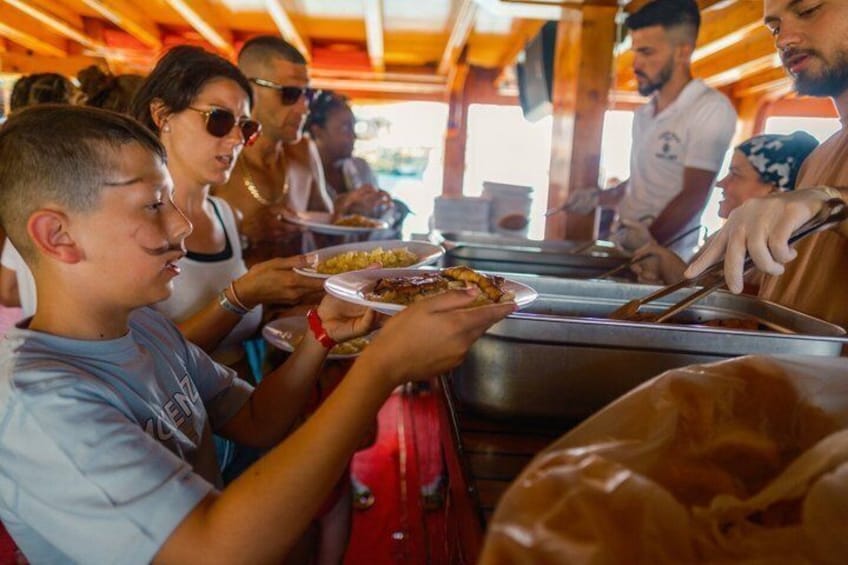 Des personnes qui déjeunent ou dînent à un buffet où les plats sont présentés sur des plateaux. 4