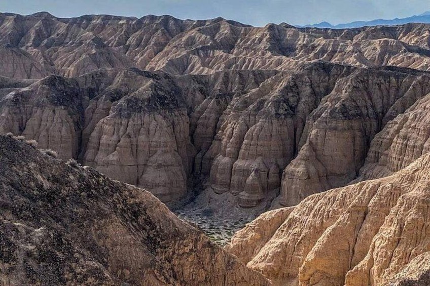 Un paisaje accidentado con marcadas formaciones por erosión y un valle profundo. 4