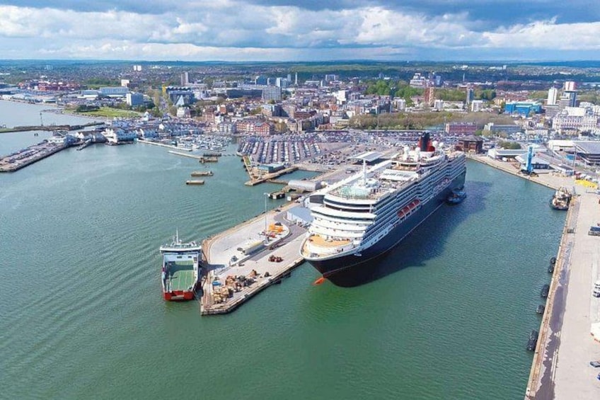 Una grande nave da crociera ormeggiata in un porto, con sullo sfondo un panorama urbano. 2
