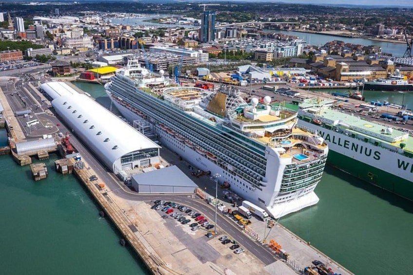 Un'imponente nave da crociera ormeggiata in un porto, con uno skyline urbano sullo sfondo. 1
