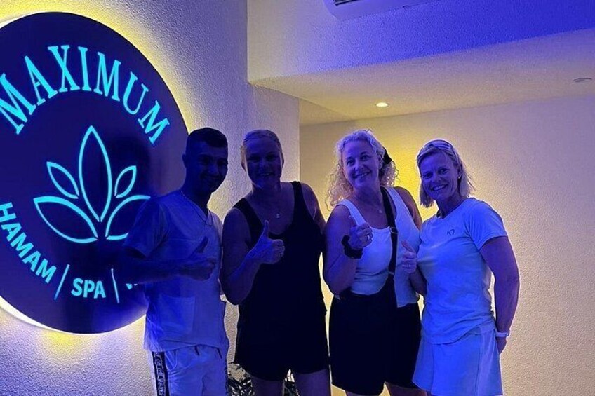 A group of people standing in front of a sign that reads 'MAXIMUM HAMAM SPA.' 2